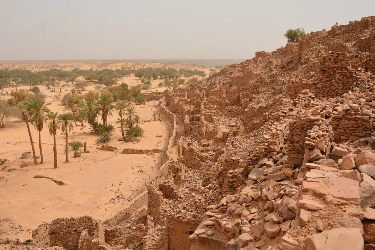 The ancient stone tower of Ouadane ksar rising above the desert at sunset, Mauritania